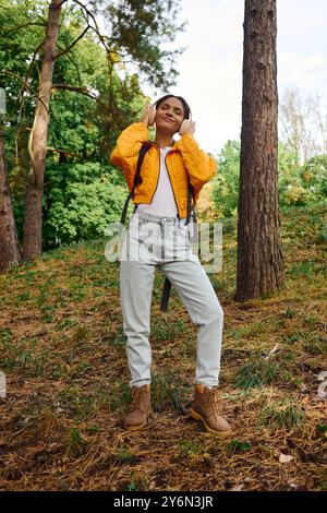 In einem bunten Herbstwald taucht eine junge Frau beim Wandern und Erkunden in die Natur ein. Stockfoto