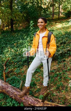 Eine junge Frau erkundet einen malerischen Waldweg und bietet während der farbenfrohen Herbstsaison Abenteuer. Stockfoto