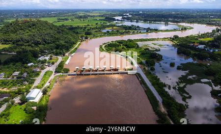 Aus der Vogelperspektive auf die Schleusen des Damms mit schnellem Wasserfluss in der Regenzeit. Stauwasser wird freigesetzt, Überkapazität nach starkem Regen. Stockfoto