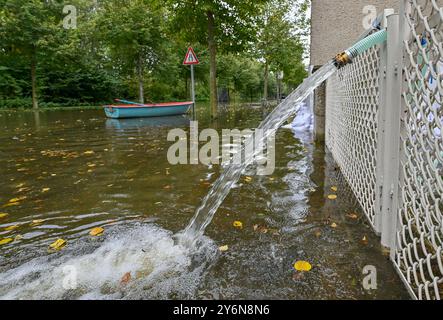 26. September 2024, Brandenburg, Frankfurt (oder): Bewohner des von der oder überfluteten Buschmühlenweges in Frankfurt (oder) pumpen Wasser aus einem Keller. In einigen Gemeinden im Hochwassergebiet entlang der oder sind die Wasserstände seit einigen Stunden zurückgegangen. Angesichts der Prognosen für die weiter nördlich gelegene Stadt Frankfurt (oder) dürfte auch der aktuelle maximale Wasserstand dort in wenigen Stunden überwunden sein. Foto: Patrick Pleul/dpa Stockfoto