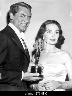 Hollywood: Schauspieler Cary Grant überreicht den Preis „Bester Schauspieler des Jahres“ an Jean Simmons, der ihn im Namen des britischen Schauspielers Alec Guinness entgegennimmt. Guinness erhält den Preis für seine Rolle in dem Film „die Brücke am Fluss Kwai“. 27. März 1958 Stockfoto