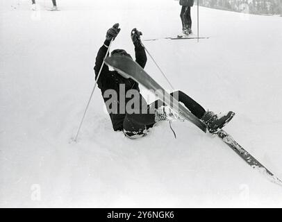 St. Moritz: Während seines ersten Skitours auf den Chantarella-Pisten hier heute stürzt John Lennon, von Englands berühmten Pop-Songstern, die Beatles, im Schnee. John, begleitet von seiner Frau cynthia, genießt derzeit einen Wintersporturlaub. 28. Januar 1965 Stockfoto