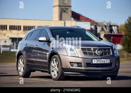 Minsk, Weißrussland - 18. September 2024: Luxus-Crossover der zweiten Generation mittelgroßer SUV Cadillac SRX 4 II parkt über urbanem Hintergrund. Stockfoto