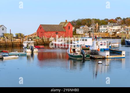 Fushing-Boote im Hafen bei Dämmerung im Herbst. Ein rotes Holzfischerhütte ist auf einem Steinkai. Stockfoto