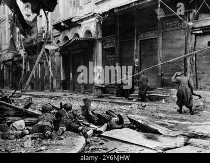 Straßenkämpfe in Athen, britische Fallschirmjäger im Einsatz. Eine Patrouille, die vorsichtig von Haus zu Haus entlang der Euripidhou Straße vorrückt, unter dem Feuer eines Maschinengewehrs, das zwischen den Trümmern an der Straßenecke aufgestellt wurde. Dezember 1945 ©2004 Topfoto Stockfoto