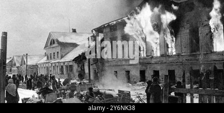 Der russische Vormarsch: Rauch und Flamme und deutsche Gräber Ein brennendes Gebäude in Kalinin, ein Foto, das kurz nach der Rückeroberung der Stadt durch die Russen aufgenommen wurde. Auf der Straße befinden sich Möbelreste, die von der Bevölkerung gerettet wurden. Der deutsche Rückzug aus Kalinin entwickelte sich zu einer Rage. Januar 1942 ©2004 Credit:Topfoto Stockfoto