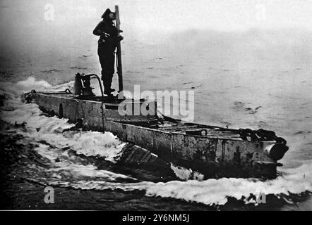 Britains Midget-U-Boote, ähnlich denen, die das deutsche Schlachtschiff Tirpitz beschädigten, stehen neben dem Periskop Ein Mitglied der Besatzung von an X Craft. Die Kleinheit des Handwerks lässt sich leicht anhand der Größe des Mannes beurteilen. ©2004 Topfoto Stockfoto