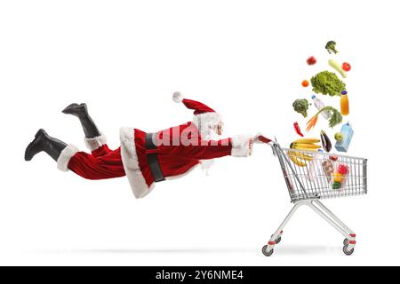 weihnachtsmann, der einen Einkaufswagen hält, in dem Lebensmittel auf weißem Hintergrund fallen Stockfoto