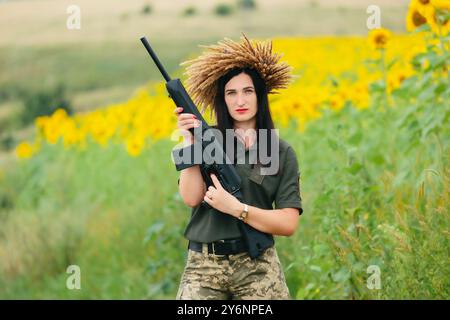 Soldatinnen in Militäruniform. Ein Mädchen in Militäruniform mit einer Waffe. Ukrainische Frau in einem Kranz. Stockfoto