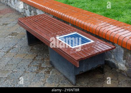 Eine Bank mit integriertem Solarpanel zum Aufladen von Telefonen. Stockfoto