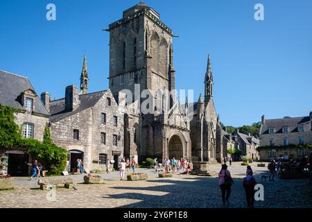 Blick auf die Kirche Saint Ronan vom Dorfplatz, alte Häuser und Touristen. Stockfoto