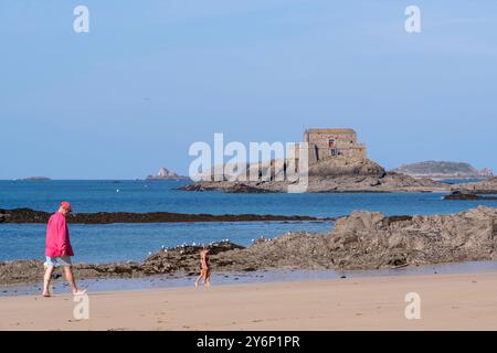 SaintMalo (Bretagne, Nordwestfrankreich): fort der Gezeiteninsel 'Petit Bé' vom Strand 'plage du Môle' aus gesehen und Spaziergänger am Strand Stockfoto