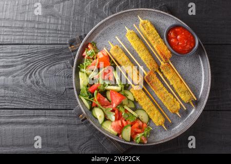 Köstliche gebratene Auberginen-Sticks mit Käse, serviert mit Gemüsesalat und Tomatensauce, Nahaufnahme auf Teller auf Holztisch. Horizontale Draufsicht von Stockfoto