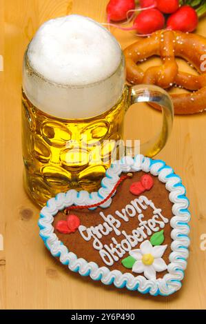 Oktoberfest in München ein Maßkrug Bier steht auf einem Holzbrett mit einem Schokoladenherz vom Oktoberfest *** Oktoberfest in München Eine Tasse Bier St Stockfoto