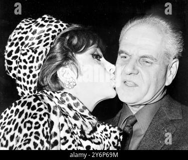 Filmstar Gina Lollobrigida küsst den französischen Filmregisseur Jean Delannoy am 8. Januar 1966 auf die Wange Stockfoto