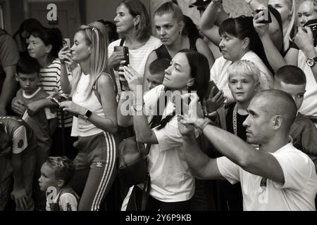 ODESSA, UKRAINE - 21. September 2024: Kinderjugendsport. Emotionale Eltern machen Fotos von den Gewinnern ihrer Kinder auf ihrem Phon Stockfoto