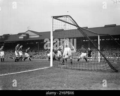 Die Spieler von Manchester City packen ihr Tor und sobald der Freistoß geübt wird , stürmen Sie in BILLINGTON , Chelsea ist innen rechts , der den Schuss direkt außerhalb des Strafraums während des Spiels der First Division am Stamford Bridge Ground in London schoss . Walsh Manchesters rechte Hälfte ( 4) und POWELL , Manchesters Torwart , beobachten das Ergebnis besorgt . Oktober 1949 Stockfoto