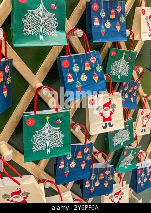 Umweltfreundlicher Zero Waste großer Adventskalender in Form eines Weihnachtsbaums mit Basteltüten und Makramee an der Wand. Hochwertige Fotos Stockfoto