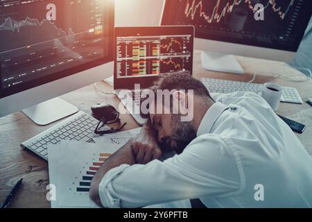 Überarbeitet. Blick von oben auf den erschöpften jungen Geschäftsmann in formeller Kleidung, der im Büro schläft Stockfoto