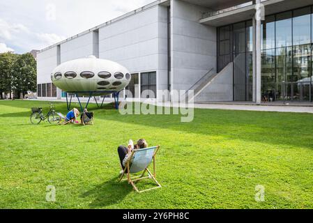 Auf dem Rasen vor der Pinakothek der Moderne und der Kunstinstallation Futuro House von Matti Suuronen, München Stockfoto