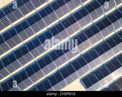 Luftaufnahme eines großen Solarmoduls auf einem gewerblichen Dach in einem sonnigen Stadtgebiet mit Lösungen für erneuerbare Energien Stockfoto