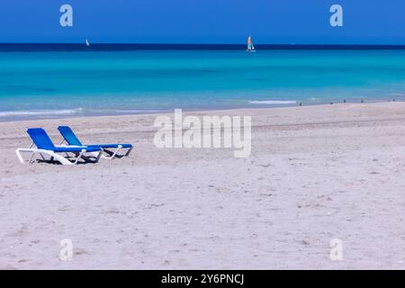 Die wunderschöne Strandfront der kubanischen Stadt Varadero in Kuba zeigt zwei Liegestühle am Sandstrand an einem sonnigen Sommertag Stockfoto