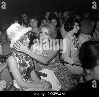 MISS ISRAEL YEHUDIT MAZOR (rechts) hilft dabei, den Hut von Miss Iceland, Anne Geirsdottir (links) auf einer Miss Universe 1962 Contest Convention am 17. Juli 1962 in Miami Beach, Florida, anzupassen Stockfoto