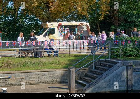 Ein Mr. Whippy-Eiswagen mit einer großen Schlange an Kunden am Flussufer in Laleham Staines an einem sonnigen Sommertag in Surrey England, Großbritannien Stockfoto