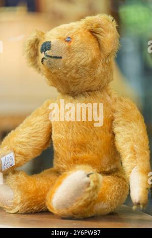 Ein altmodischer Kinderteddybär zum Verkauf, in einem Schaufenster. Sieht ziemlich skurril aus. Stockfoto