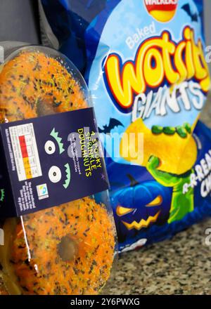 London, England, 26. September 2024: Halloween Branded Food, Tasche mit Crisps und Donuts in der Küche Close-up Stockfoto