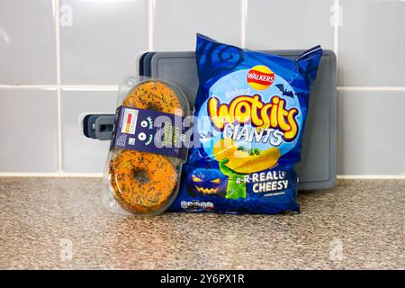 London, England, 26. September 2024: Halloween-Branding-Essen, Beutel mit Crisps und Donuts in der Küche Stockfoto