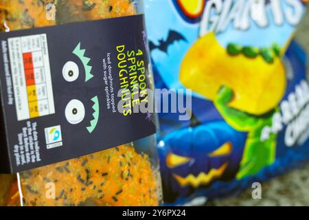 London, England, 26. September 2024: Halloween Branded Food, Tasche mit Crisps und Donuts in der Küche Close-up Stockfoto