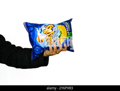 London, England, 26. September 2024: Arm packt eine Tasche mit Halloween Walkers Wotsits mit weißem Hintergrund und Branding für 2024 Halloween Stockfoto