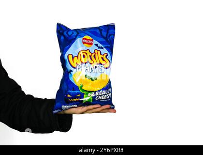 London, England, 26. September 2024: Arm packt eine Tasche mit Halloween Walkers Wotsits mit weißem Hintergrund und Branding für 2024 Halloween Stockfoto