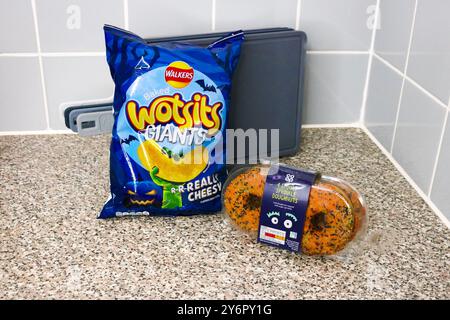 London, England, 26. September 2024: Halloween-Branding-Essen, Beutel mit Crisps und Donuts in der Küche zu Hause Stockfoto