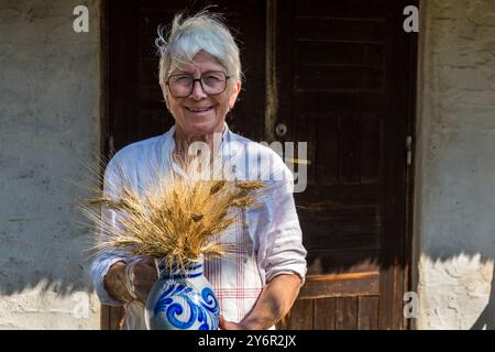 Britta Ossler mit Hartweizen. Sie und ihr Ehemann begannen 1994 mit dem Durum auf Hven zu wachsen. Das wärmere Mikroklima auf der Insel im Öresund ermöglicht den Anbau. Hartweizenbäckerei auf der Insel Ven. Landsvägen, Landskrona kommun, Skåne, Schweden Stockfoto
