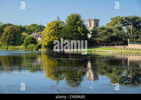 Der Turm von Saint Michael mit der Kirche Saint Mary, mit der Flagge Saint George, spiegelt sich in Melbourne Pool, Melbourne, Derbyshire, England Stockfoto