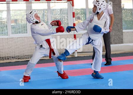 ODESSA, UKRAINE- 21. September 2024: Kinder- und Jugendsport. Kinder-Jungen und Mädchen führen Karatekämpfe auf Tatami-Kindersportarten durch. Gesundes Leben Stockfoto