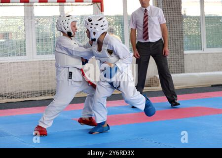 ODESSA, UKRAINE- 21. September 2024: Kinder- und Jugendsport. Kinder-Jungen und Mädchen führen Karatekämpfe auf Tatami-Kindersportarten durch. Gesundes Leben Stockfoto