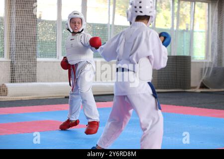 ODESSA, UKRAINE- 21. September 2024: Kinder- und Jugendsport. Kinder-Jungen und Mädchen führen Karatekämpfe auf Tatami-Kindersportarten durch. Gesundes Leben Stockfoto