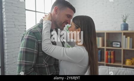 Ein liebevolles hispanisches Paar umarmt sich herzlich in ihrem gemütlichen Wohnzimmer und teilt einen intimen Moment auf einem komfortablen Sofa. Stockfoto