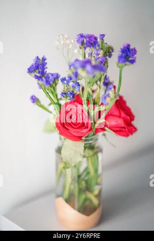 Ein Strauß frischer Rosen mit Babyatmung in einem Glas Wasserglas auf weißem Hintergrund. Stockfoto