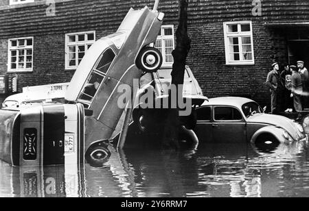 AM 19. FEBRUAR 1962 STAPELTEN SICH AUTOS ÜBEREINANDER, ALS DAS HOCHWASSER IN WILHELMSBURG, HAMBURG, ZURÜCKGEHT. DIESES GEBIET WAR AM SCHLIMMSTEN BETROFFEN, DA DIE ZAHL DER TODESOPFER BEI DER KATASTROPHE 115 BETRUG. Stockfoto