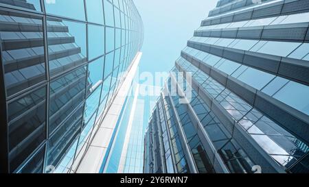 Moderne Wolkenkratzer, die sich in Richtung eines klaren blauen Himmels in einer geschäftigen städtischen Umgebung erheben Stockfoto