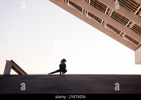 Athlet, der während des Trainings seitlich hockt Stockfoto