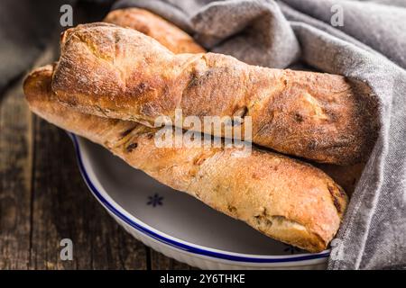 Knuspriges rustikales Baguette in einer Schüssel auf einem Holztisch. Stockfoto