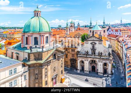 Krizovnicke-Platz in Prag, Tschechien. Die Kirche des Heiligen Franziskus von Assisi dominiert den Vordergrund mit ihrer markanten grünen Kuppel und der überragenden Fassade. Die Kirche St. Salvator befindet sich auf der rechten Seite mit ihrem bogenförmigen Eingang und den komplizierten Details. Stockfoto