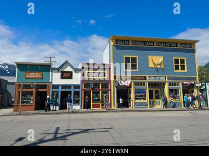 Ein Block von Geschäften an der Broadway Avenue in Skagway, Alaska, bietet eine Vielzahl von Angeboten für Touristen an einem Sommertag. Stockfoto