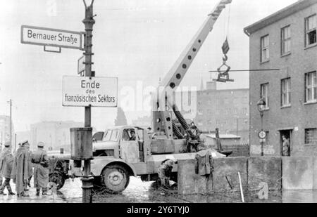 Die DDR-Volkspolizei verstärkt die Stacheldrahtschranke zwischen der sowjetischen und der französischen Zone Berlins . Schwere Betonplatten werden errichtet , um Ost-Berlin von den westlichen Sektoren abzugrenzen . AUGUST 1961 Stockfoto