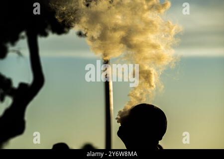 Salvador, Bahia, Brasilien - 21. Dezember 2019: Ein nicht identifizierter Mann in Silhouette wird gesehen, wie er draußen eine Rauchwolke dampft und ausatmet. Salvador, Bahia. Stockfoto